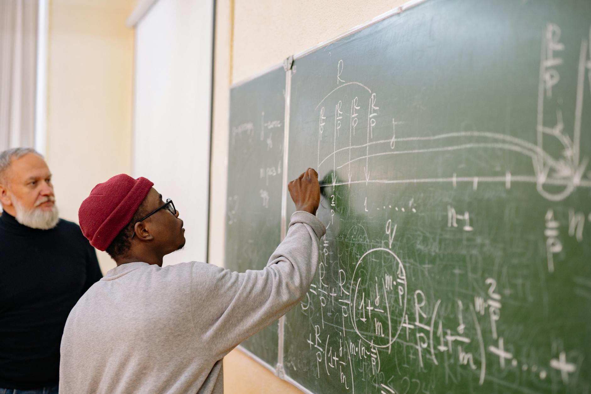 student answering the questions on a black board